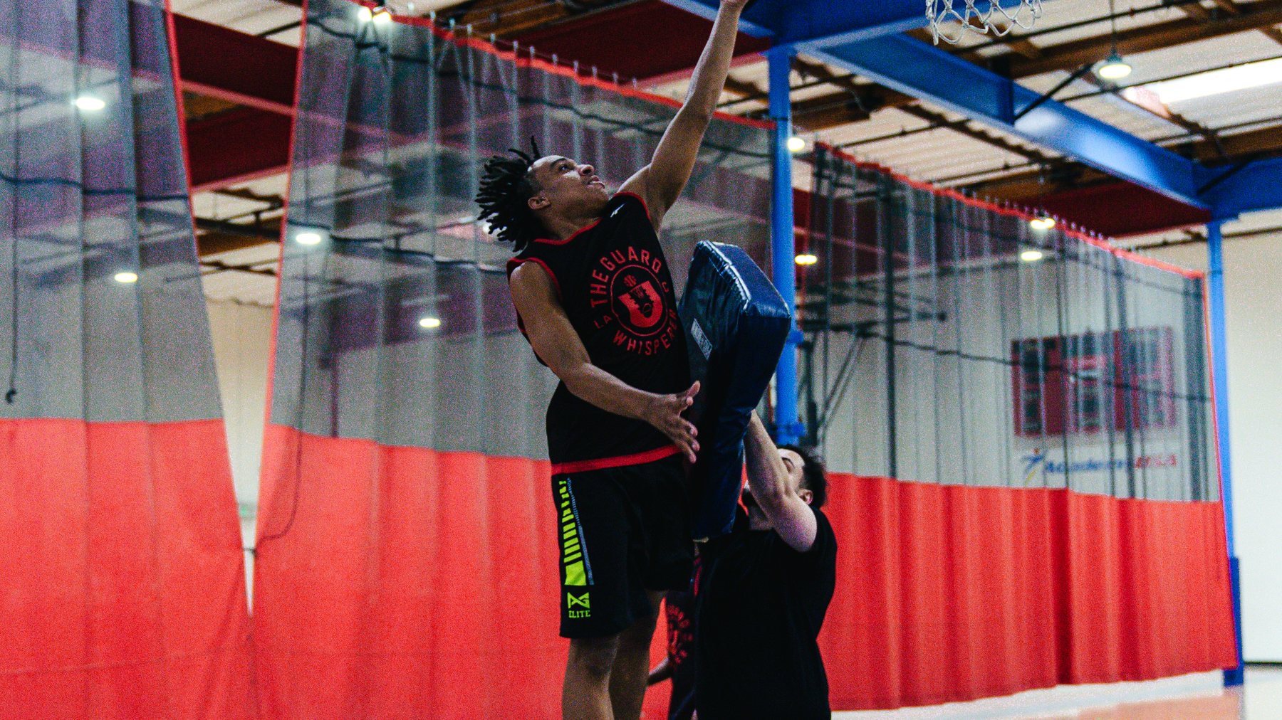 The U athlete finishing through contact at the rim