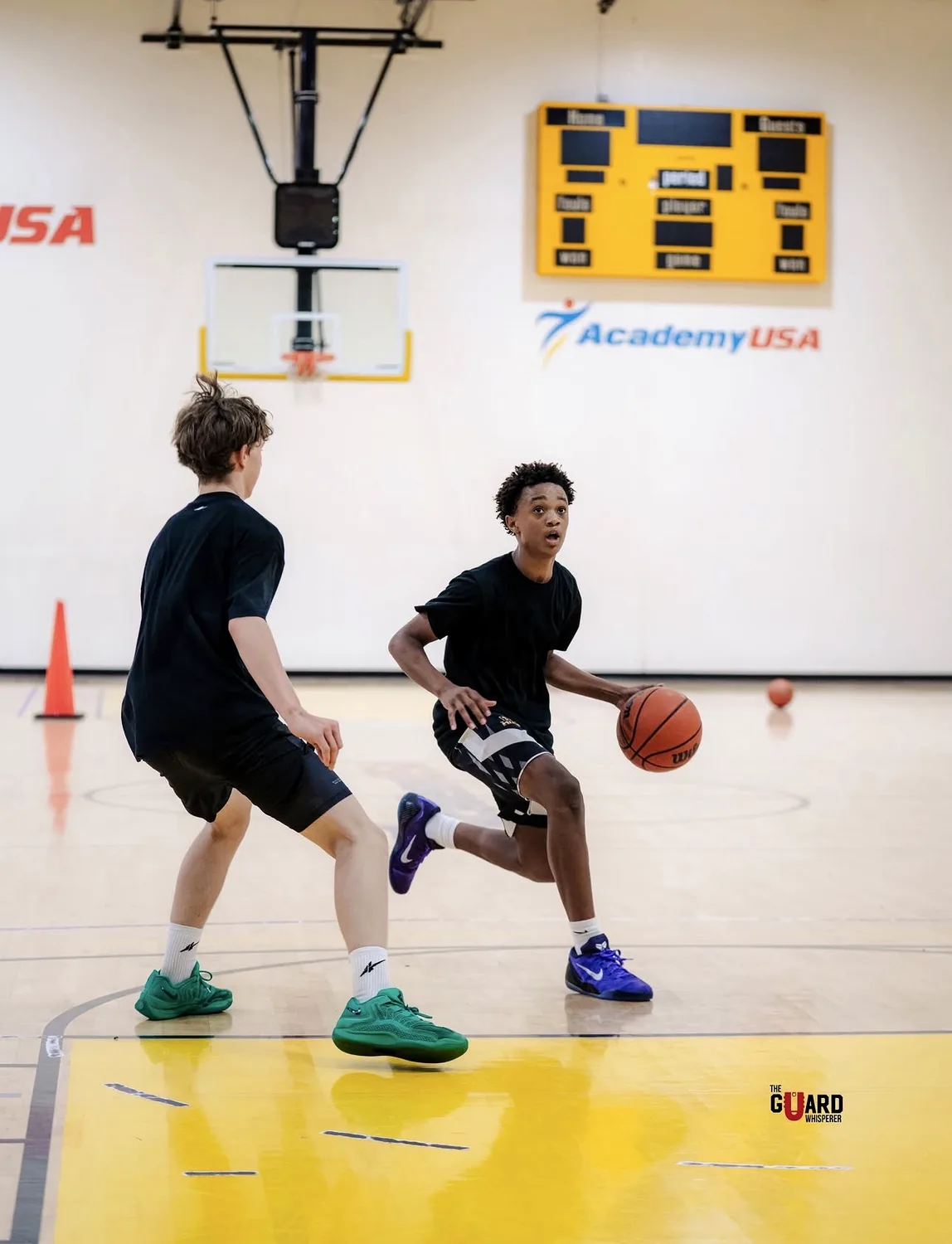 Two The U athletes battling 1v1 on the yellow court